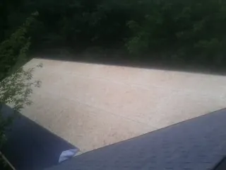 New OSB roof sheathing installed beside an existing shingle roof in Windsor